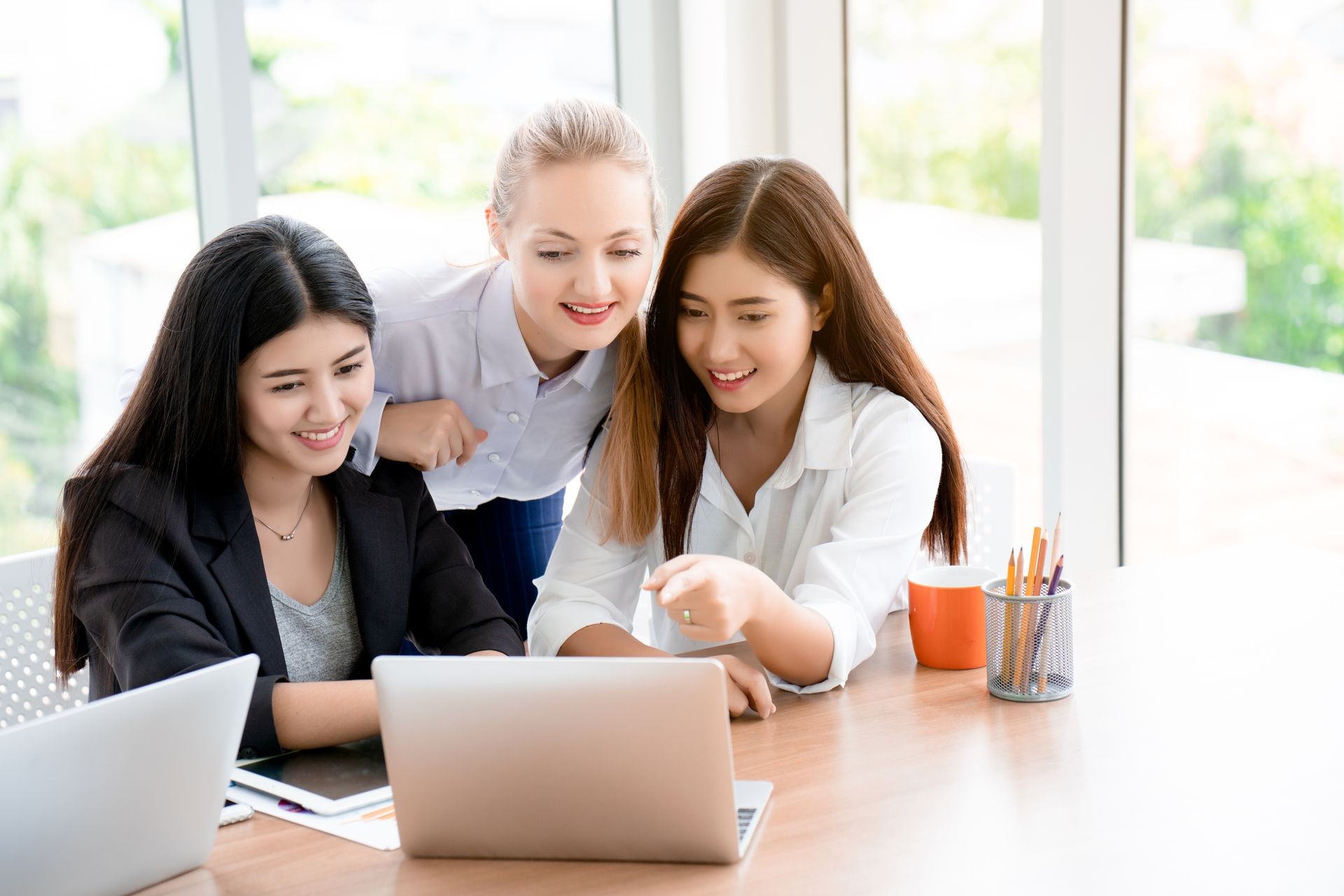 Group of business women talk about marketing planning in the office laugh happily With both Caucasian and Asian. Teach and learn how  work strategy effectively and achieve goals. Concept Honesty work